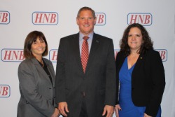 Two HNB employees take picture with David Raven.